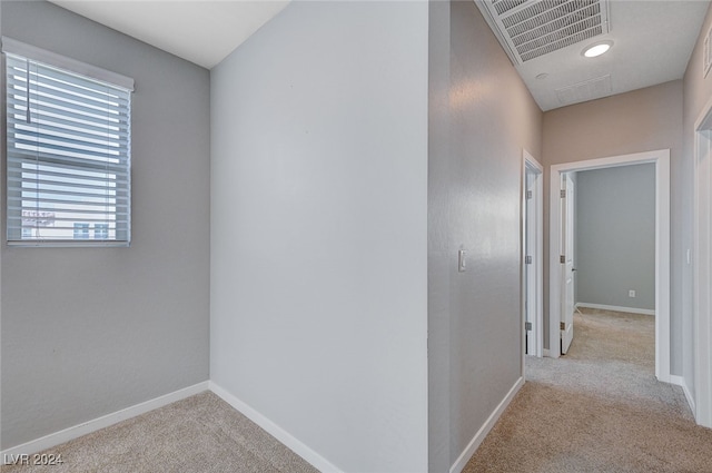 hallway featuring light colored carpet