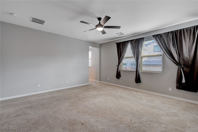 spare room featuring ceiling fan and light carpet