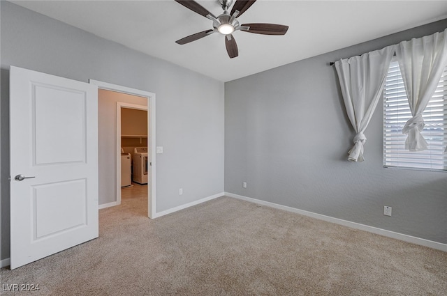 unfurnished room with light carpet, washer and dryer, and ceiling fan