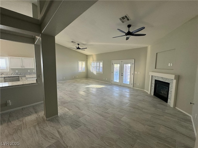 unfurnished living room with ceiling fan and lofted ceiling