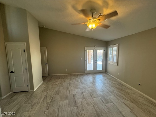 spare room with lofted ceiling, light hardwood / wood-style flooring, french doors, and ceiling fan