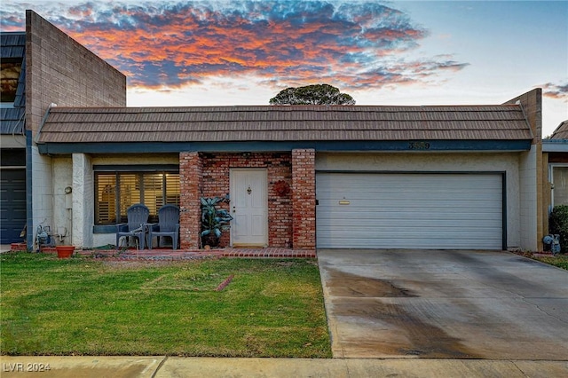 view of front of property featuring a yard and a garage