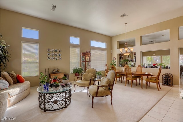 tiled living room featuring a towering ceiling, a wealth of natural light, and a chandelier