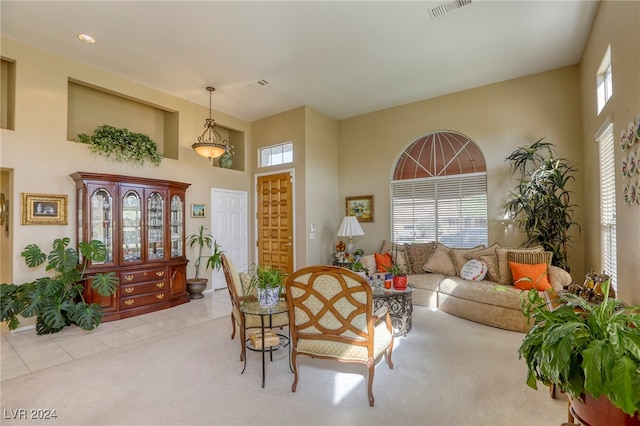 carpeted living room featuring a towering ceiling and plenty of natural light