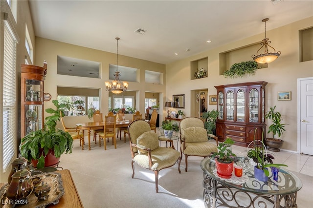 living room with a high ceiling, light carpet, and an inviting chandelier