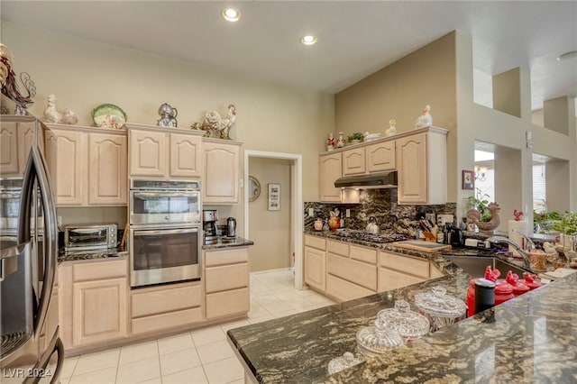 kitchen with stainless steel appliances, light brown cabinetry, and sink