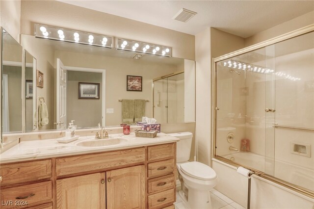 full bathroom with toilet, enclosed tub / shower combo, vanity, and tile patterned flooring