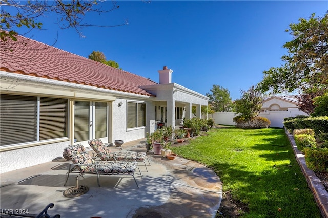 rear view of house featuring a yard and a patio