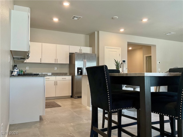 kitchen with white cabinetry and stainless steel refrigerator with ice dispenser