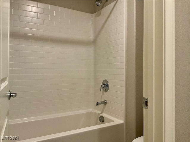 bathroom with tiled shower / bath and toilet