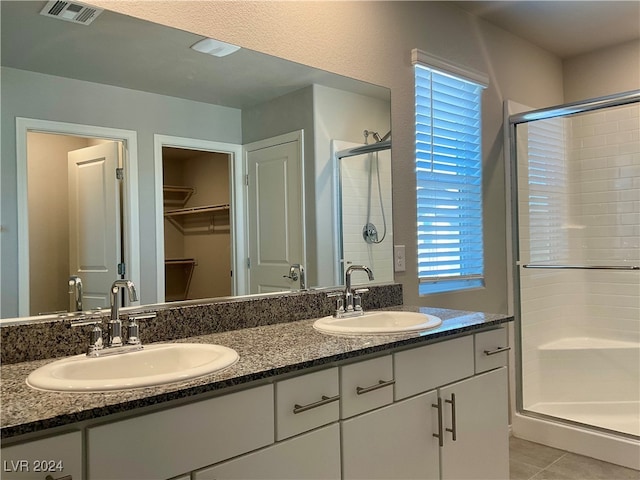 bathroom featuring vanity, a shower with shower door, and tile patterned flooring