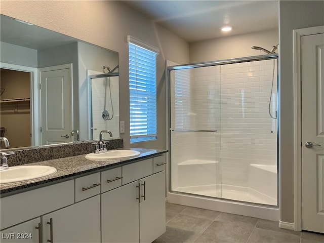 bathroom with walk in shower, vanity, tile patterned floors, and plenty of natural light