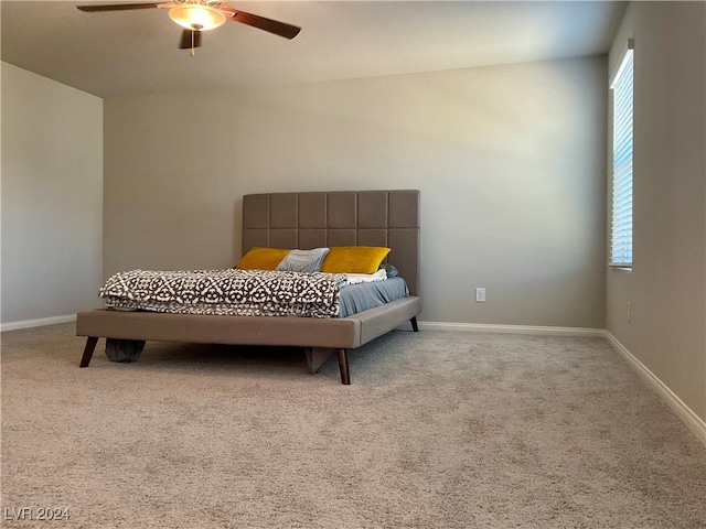 bedroom featuring light carpet, multiple windows, and ceiling fan