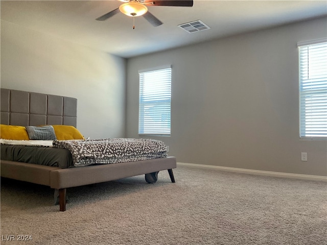 carpeted bedroom featuring ceiling fan and multiple windows