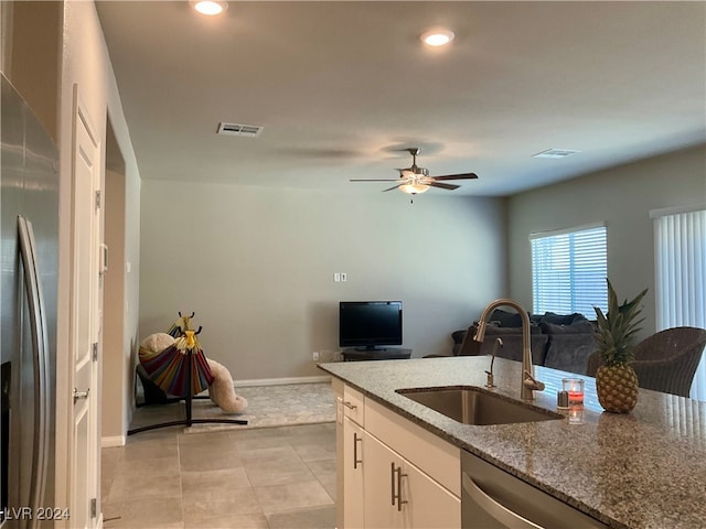 kitchen featuring stone counters, sink, ceiling fan, stainless steel appliances, and white cabinets