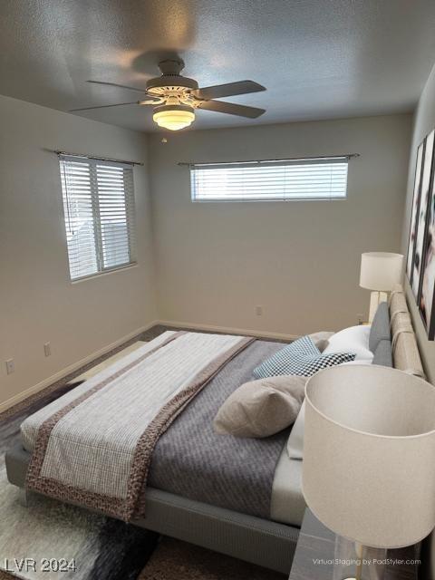 491 Marina Cv, Boulder City, NV 89005 - bedroom with multiple windows, baseboards, a textured ceiling, and ceiling fan
