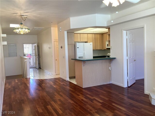 491 Marina Cv, Boulder City, NV 89005 - kitchen featuring white appliances, dark countertops, wood finished floors, a kitchen breakfast bar, and baseboards