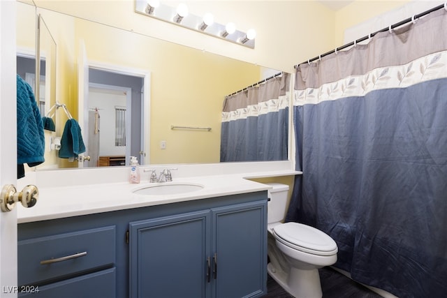 bathroom featuring vanity, toilet, and walk in shower