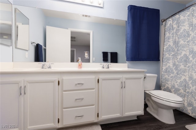 bathroom with toilet, curtained shower, hardwood / wood-style flooring, and vanity