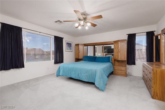 carpeted bedroom with multiple windows and ceiling fan