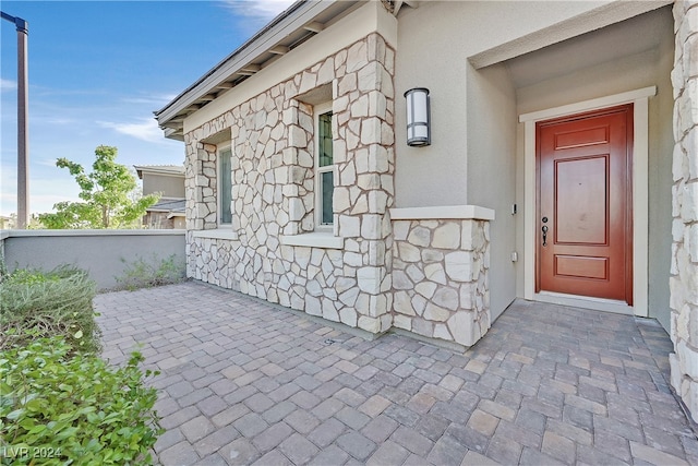 view of exterior entry with a patio area