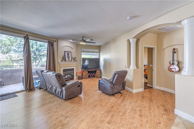 living room featuring plenty of natural light, light hardwood / wood-style flooring, and a textured ceiling