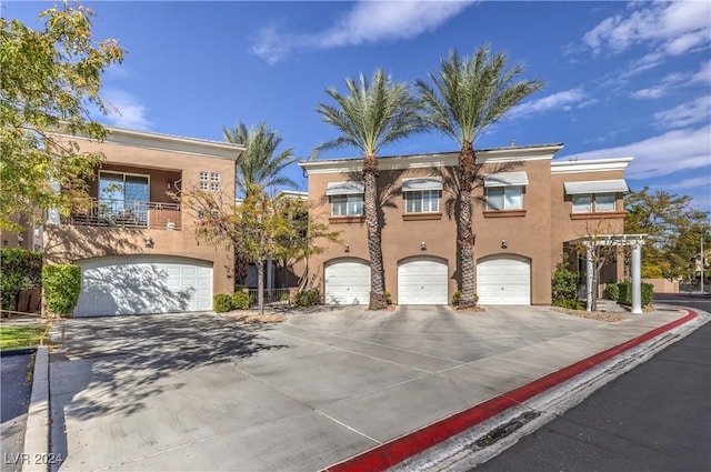 view of property with a garage and a balcony