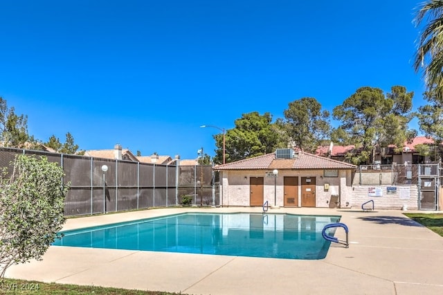 view of swimming pool featuring cooling unit and a patio area