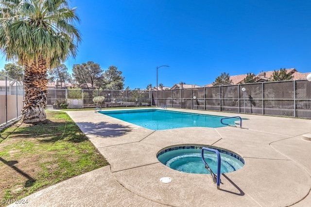 view of pool featuring an in ground hot tub and a patio