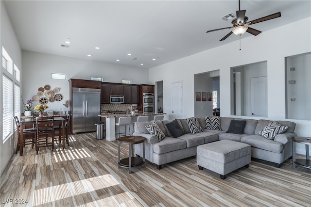 living room featuring light hardwood / wood-style floors and ceiling fan