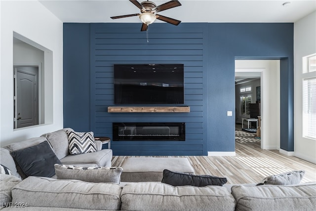 living room with a fireplace, wood-type flooring, and ceiling fan