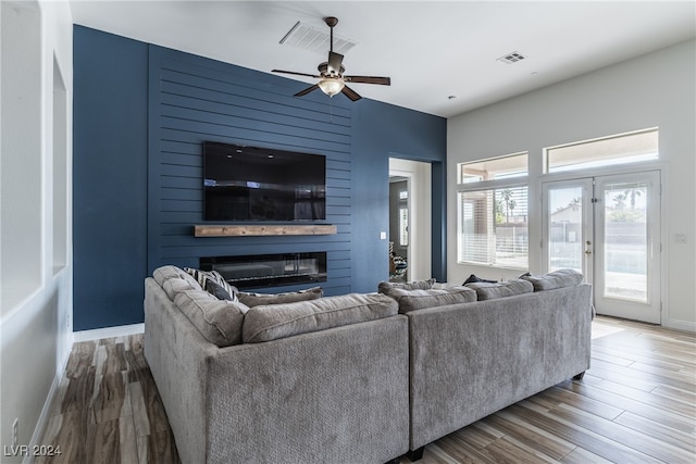 living room with wood-type flooring, a fireplace, and ceiling fan