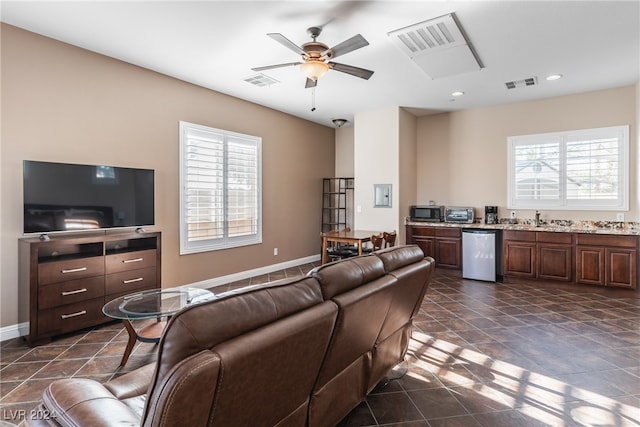 living room featuring sink, plenty of natural light, and ceiling fan