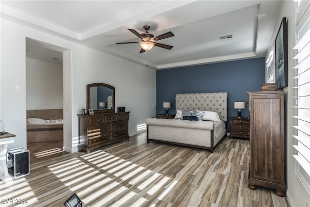 bedroom with connected bathroom, ceiling fan, and hardwood / wood-style floors