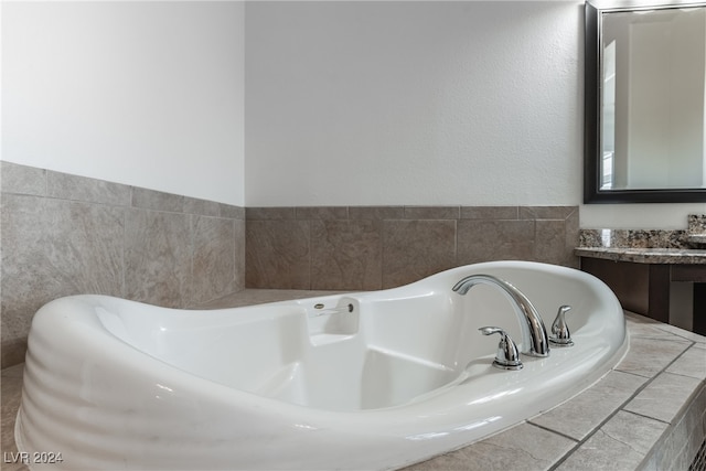 bathroom featuring vanity and a relaxing tiled tub