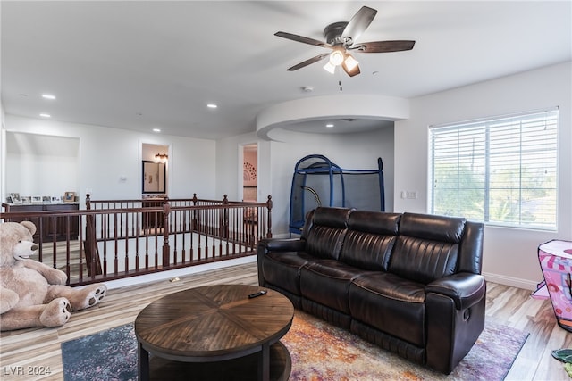 living room featuring light hardwood / wood-style flooring and ceiling fan