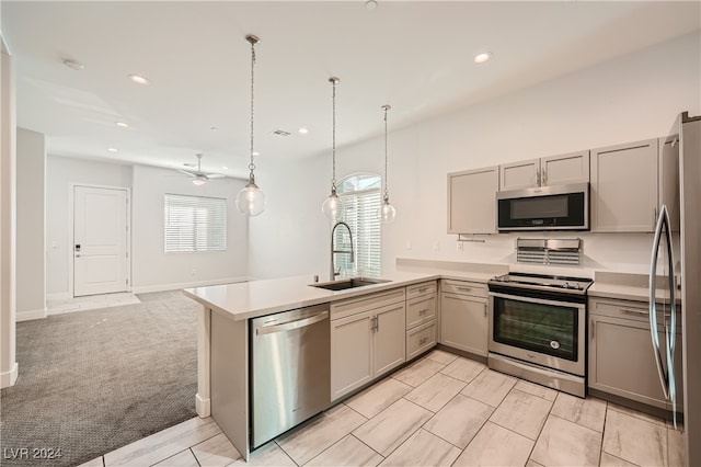 kitchen with sink, hanging light fixtures, stainless steel appliances, kitchen peninsula, and light carpet