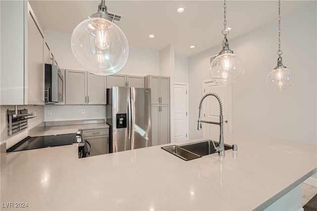 kitchen with kitchen peninsula, appliances with stainless steel finishes, sink, pendant lighting, and gray cabinets