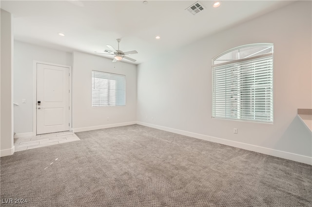 carpeted spare room with ceiling fan