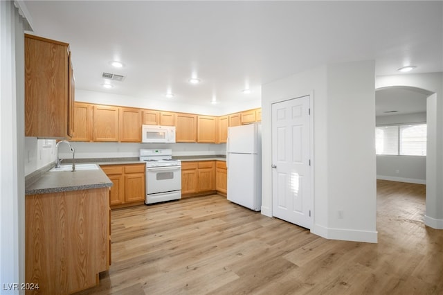 kitchen featuring light brown cabinetry, sink, light wood-type flooring, and white appliances