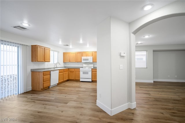 kitchen featuring white appliances, light hardwood / wood-style flooring, and a wealth of natural light