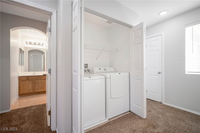 washroom with washer and clothes dryer, a healthy amount of sunlight, sink, and dark carpet