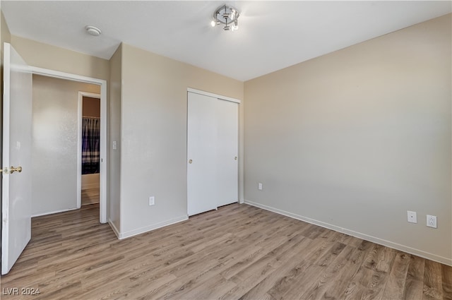 unfurnished bedroom with a closet and light hardwood / wood-style flooring