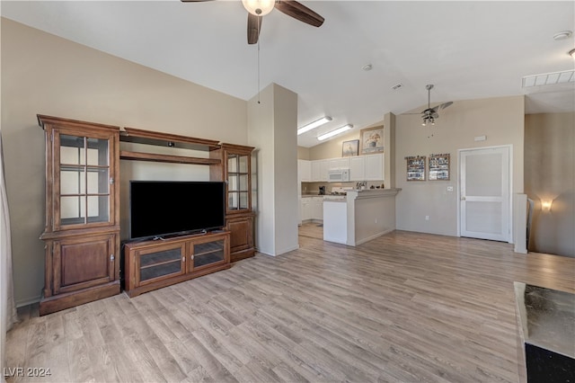 unfurnished living room featuring vaulted ceiling, light wood-type flooring, and ceiling fan