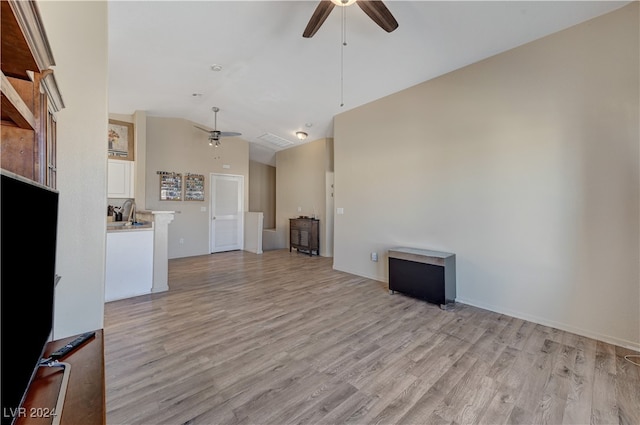 unfurnished living room with high vaulted ceiling, light hardwood / wood-style floors, and ceiling fan