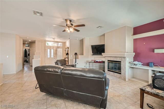 living room with a fireplace, light tile patterned floors, and ceiling fan