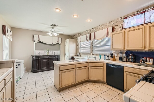 kitchen featuring tile countertops, dishwasher, and a healthy amount of sunlight