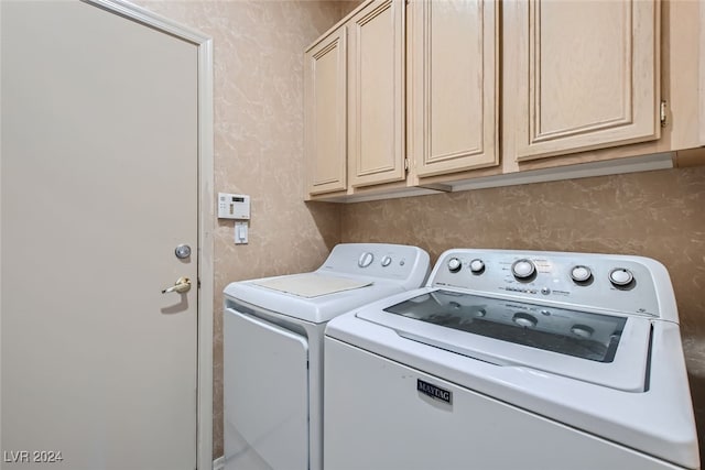 washroom with cabinets and washing machine and clothes dryer