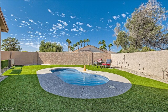 view of pool with a patio and a lawn