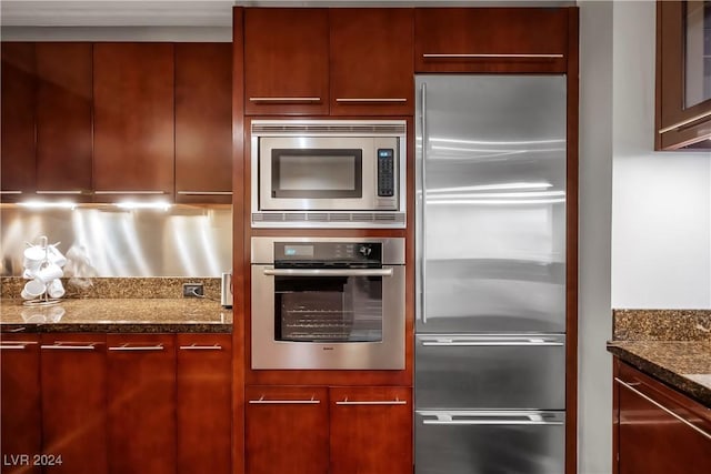 kitchen featuring dark stone counters, built in appliances, modern cabinets, and dark brown cabinets